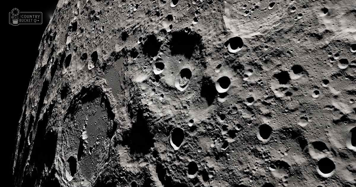 The lunar surface under a dark, outer space sky, illuminated by sunlight with shades of gray and black dominating the scene.