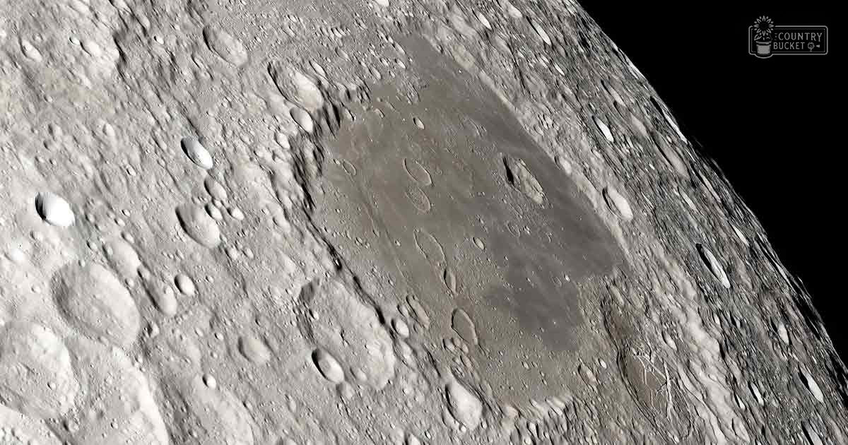 Close-up view of the moon's surface with craters and maria, illuminated by sunlight or another celestial body. Text in the top right corner reads 'Madly Odd'.