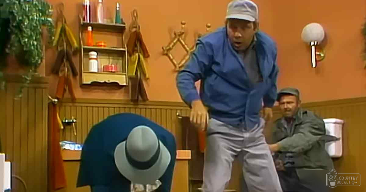 Indoors, possibly bar or restaurant, wooden paneling, hanging coats, small potted plant, orange wall, brown furniture, blue jacket, green cap, gray hat, casual setting