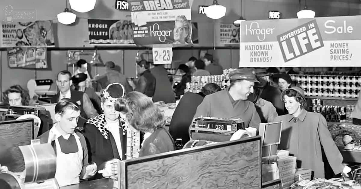 A mid-20th century grocery store checkout area with a child wearing a dark jacket, an adult male cashier in his 20s-30s, and various products on shelves.