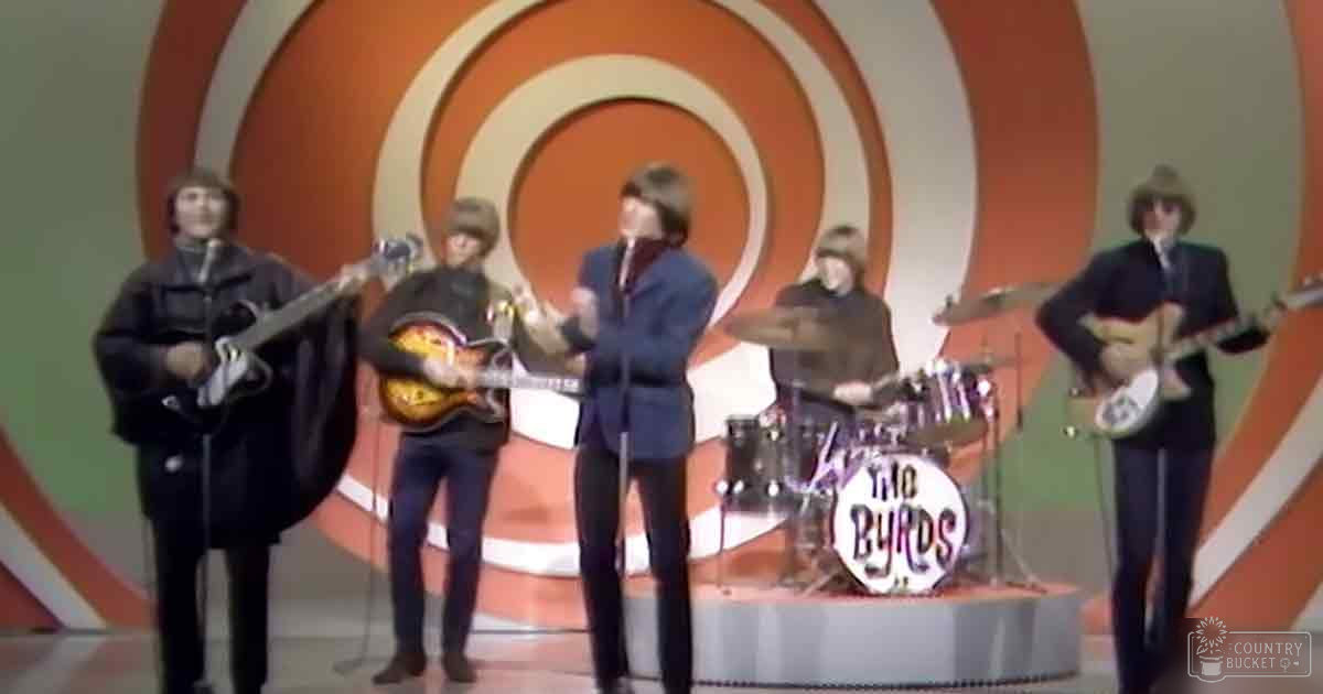 A musical performance by 'The Byrds' in a studio setting with concentric orange and white circles backdrop, bright lighting from the 1960s era.