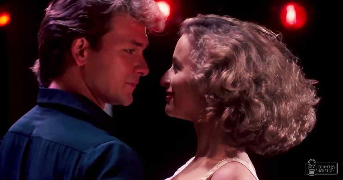 Two adults in a romantic indoor scene with red lighting, dark background, nighttime atmosphere.