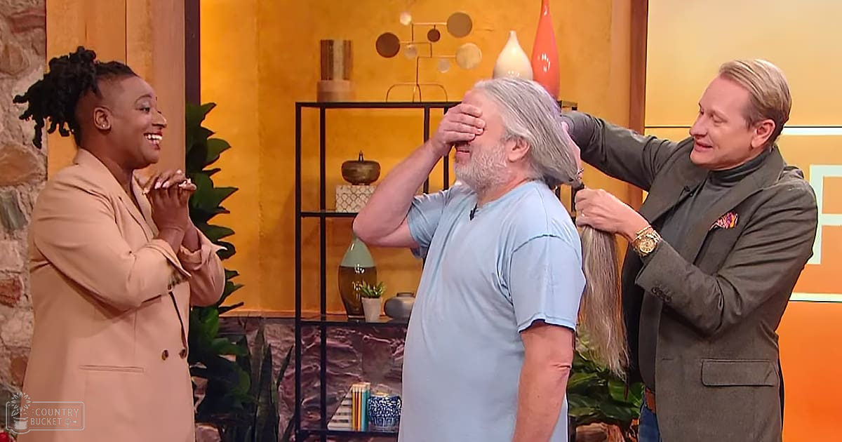 A middle-aged man with gray hair being styled by a person in a studio setting, surrounded by another woman and an older male stylist wearing formal attire.
