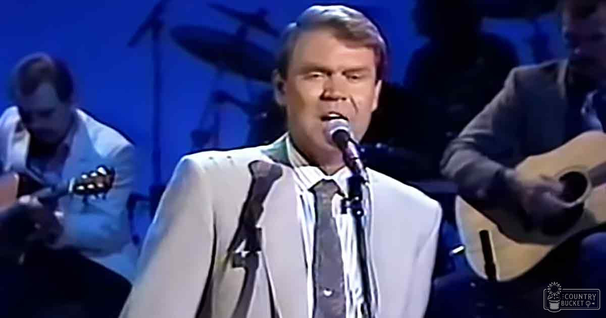 Stage performance with musicians and a performer singing into a microphone under stage lighting.