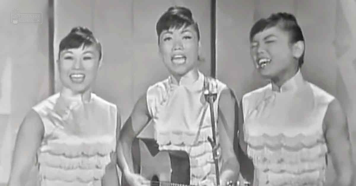 A musical performance scene with young adult female performers in sleeveless dresses on a stage set against a simple backdrop typical of mid-20th century television shows.