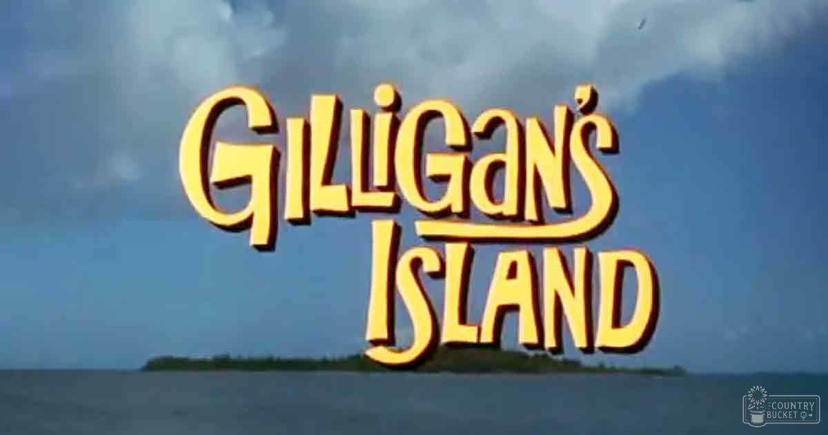 An outdoor scene with 'GILLIGAN'S ISLAND' text prominently displayed against a backdrop of water and sky, suggesting an opening title sequence for a TV show.