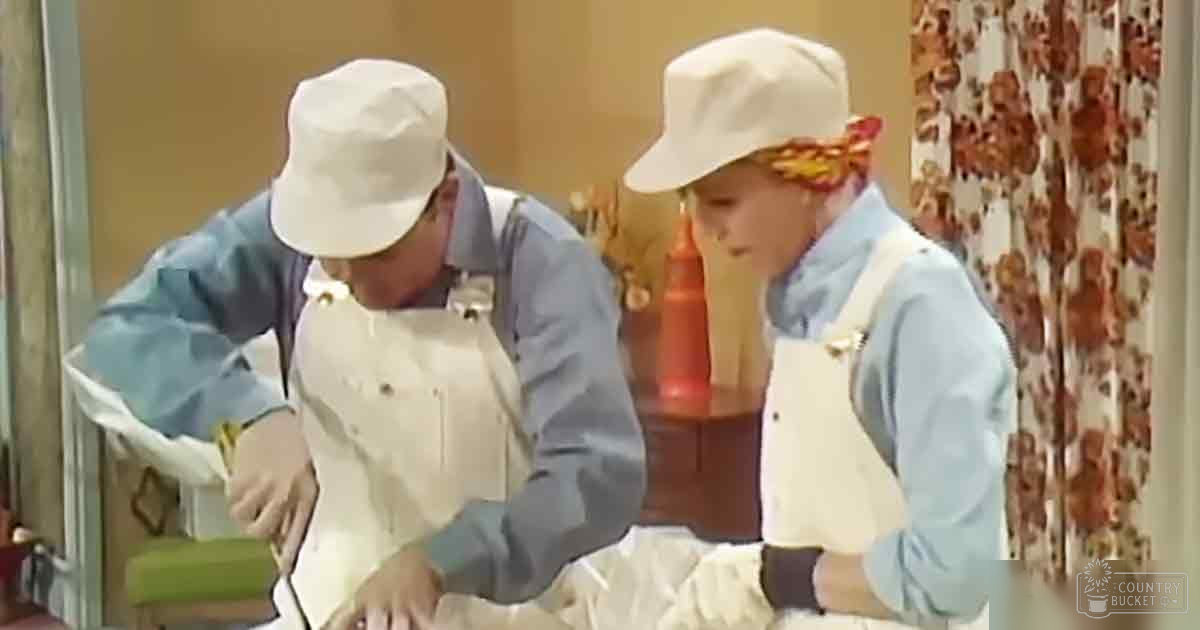Two adults wearing aprons in a kitchen setting with natural light.