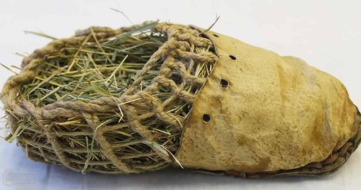 Handmade hay bale secured by rope on indoor surface.