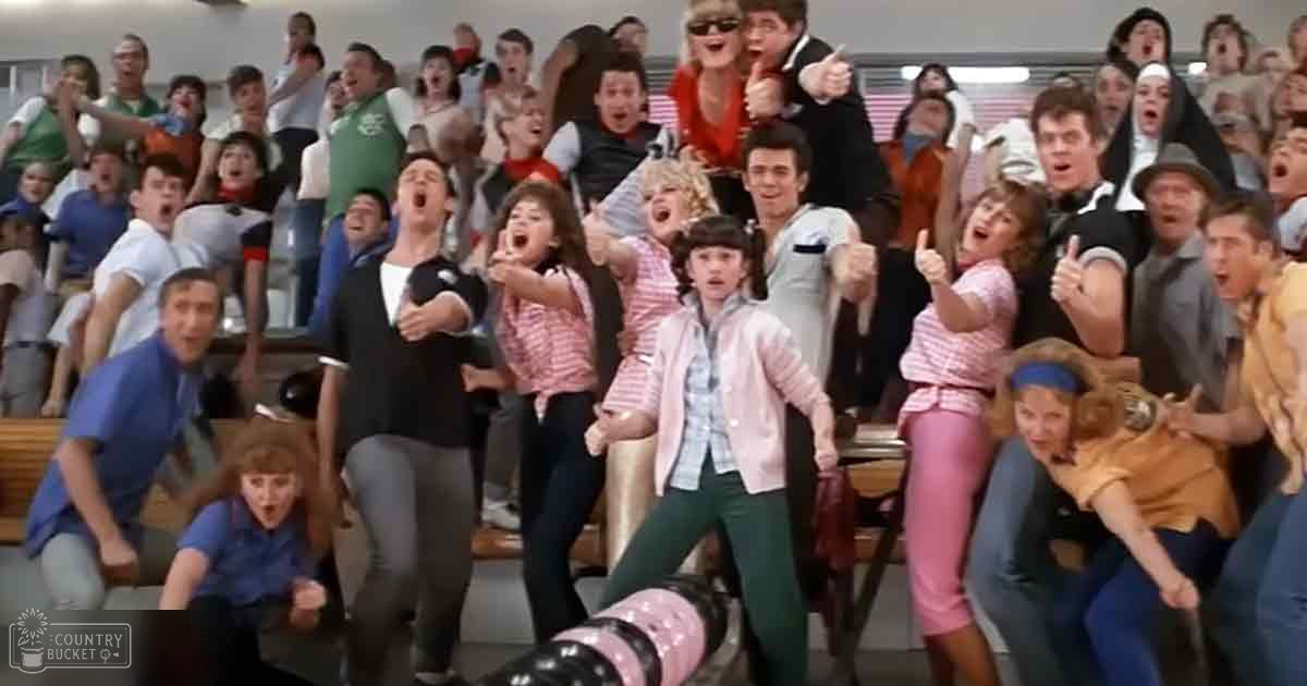 Children and teens in casual attire filling a tiered indoor venue on a sunny day.