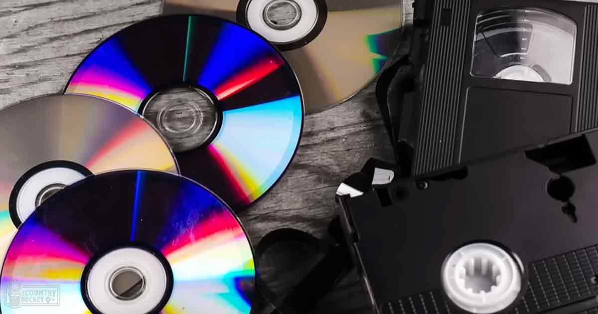 Various CDs with reflective rainbow-like colors on a wooden surface indoors, natural light suggests daytime.