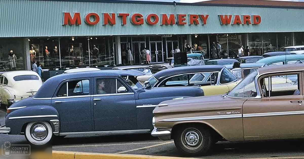 Urban daytime scene with Montgomery Ward store entrance and parked cars, mid-20th century vehicles and clothing styles.