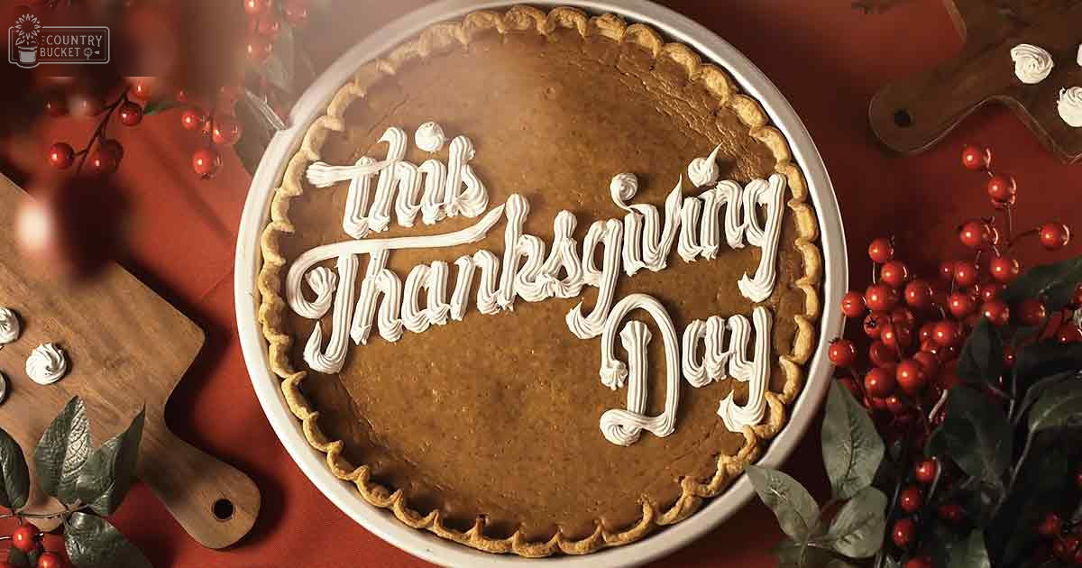 A pumpkin pie with "This Thanksgiving Day" written in icing, surrounded by red berries and green foliage on a wooden cutting board. The scene is set indoors with warm lighting, suggesting an autumnal theme.