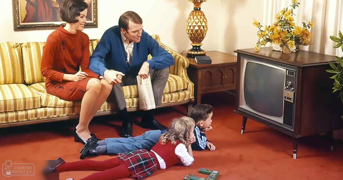 A family of four in a cozy living room with soft lighting, with reds, yellows, blues, whites, and beiges.