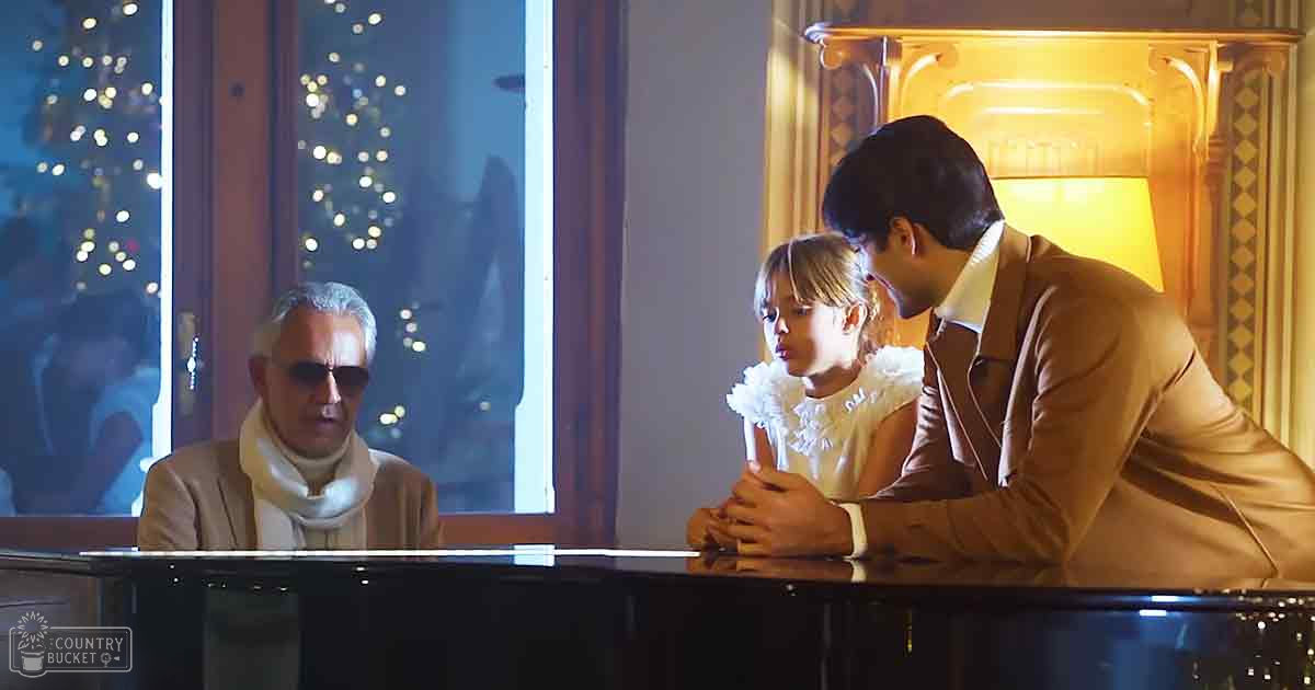 A musical performance indoors with adults in formal attire and a grand piano as focal point under ornate lighting during winter.