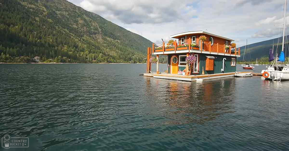 A serene lakeside setting with mountains in the background, with a houseboat adorned with potted plants. The tranquil lake is surrounded by lush greenery under soft natural lighting.