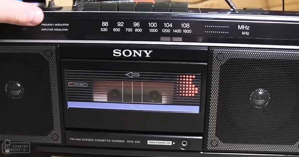 A close-up view of a vintage Sony FM/AM stereo cassette-corder model CFS-230 with 'Walkman In' labeled on it, showing radio frequencies and an audio cassette in the deck. The device is set against an indoor background.
