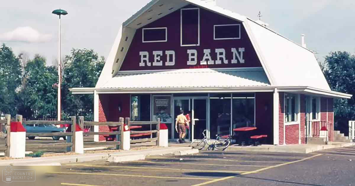 Red Barn restaurant with a young adult male in yellow shirt, brown shorts, and black shoes carrying a red bag or backpack, set against an outdoor scene with picnic tables and bicycles near the entrance.