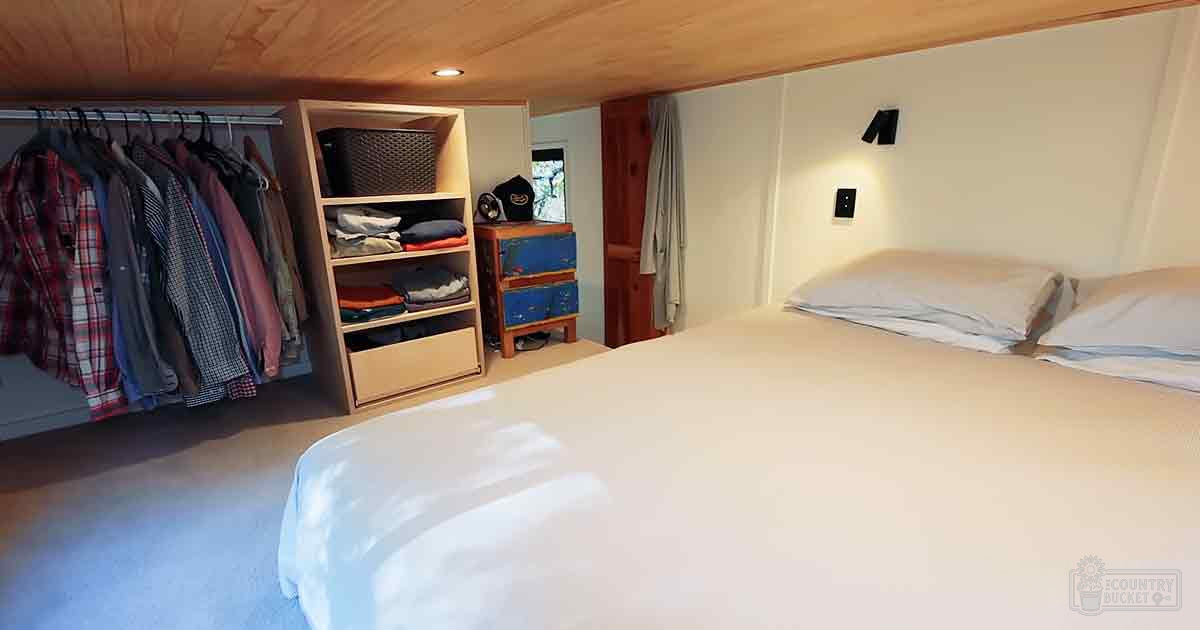 Compact bedroom scene with wooden furniture and soft lighting, indoor setting.