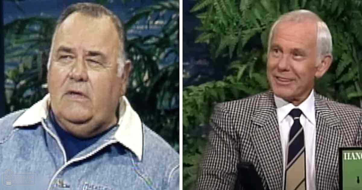 Two older adult men in a studio setting, one wearing a denim jacket over a white collared shirt, the other in a checkered blazer with a striped tie; green foliage and even indoor lighting suggest a controlled studio environment.