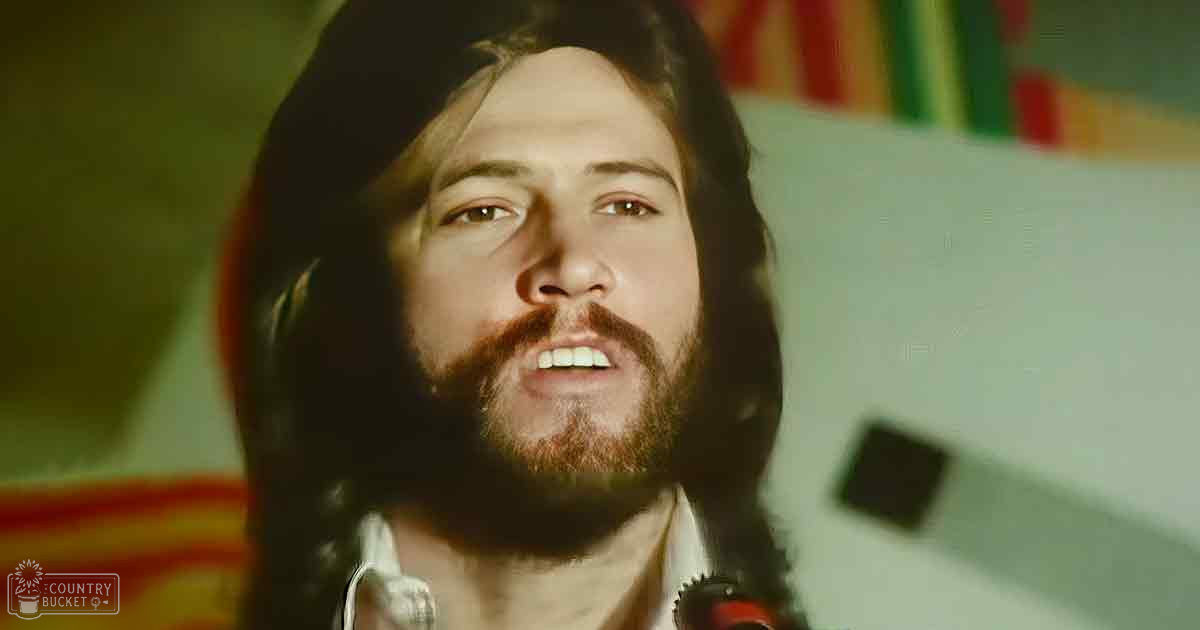 An adult male wearing a mid-20th-century style white shirt indoors with natural lighting creating shadows on his face.