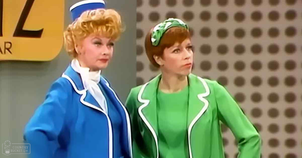 Two women in a professional studio setting; one wears a blue jacket and white hat, the other a green jacket with floral headband.
