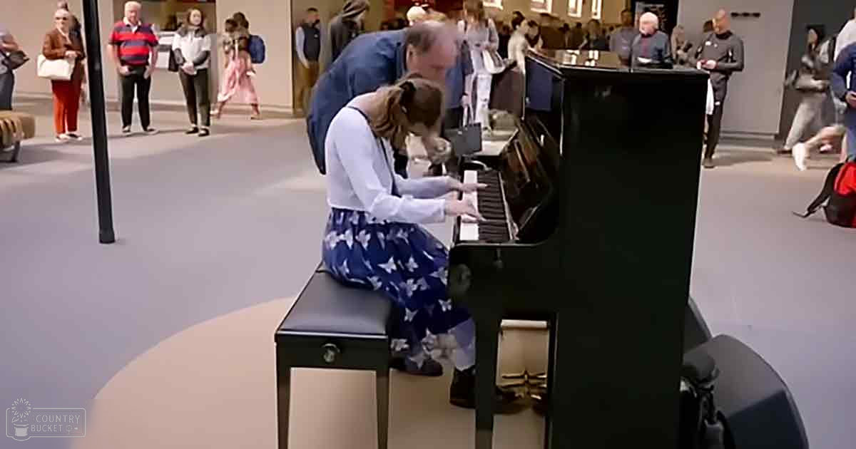 A young girl plays piano amidst an indoor art gallery or museum setting with other visitors, suggesting a historical reenactment.