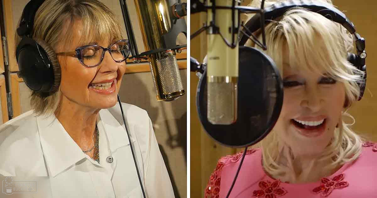 A middle-aged woman in a recording studio, wearing a white button-up shirt with black headphones and glasses, alongside another individual in a pink floral garment. The setting is an indoor professional environment with neutral wood paneling or acoustic foam.