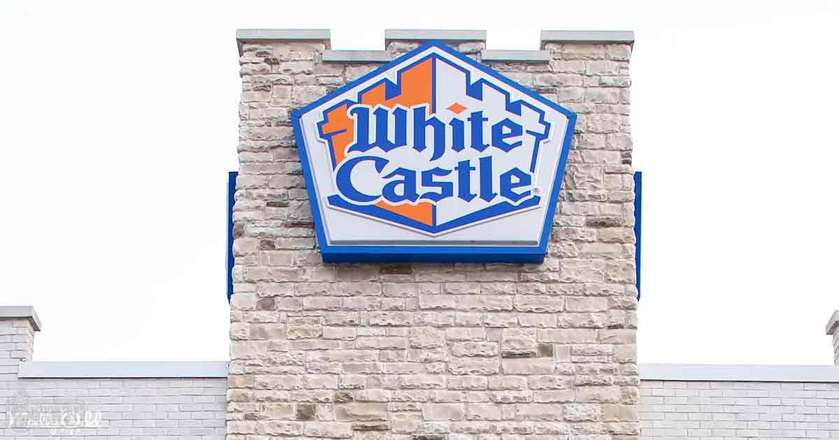 White Castle sign on a brick wall, bright daytime sky, clear lighting.