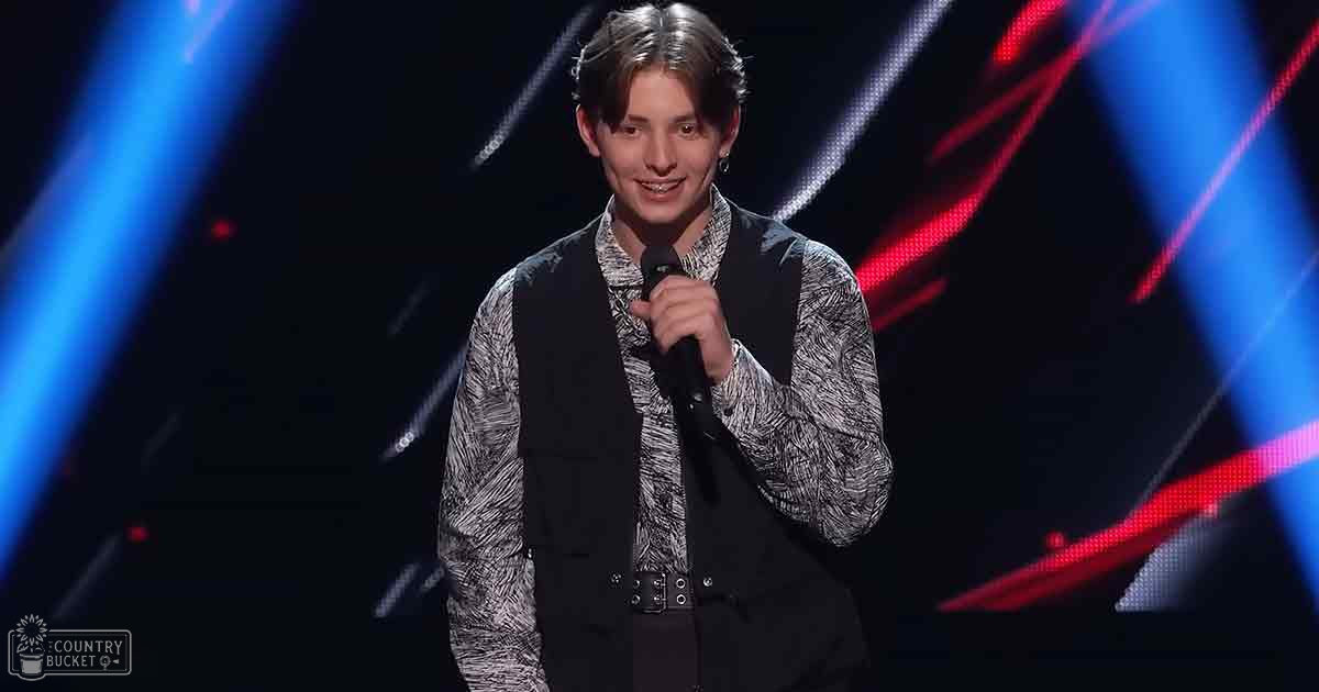 A young adult male wearing a black vest and patterned shirt performs on a stage illuminated by red and blue beams with the text 'Madly Odd' in the corner.
