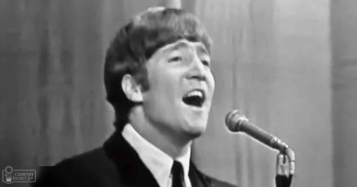 A young adult male in a dark suit jacket, white collared shirt, and black tie sings into a microphone, likely mid-20th century style, with 'Madly Odd' text visible on the stand.