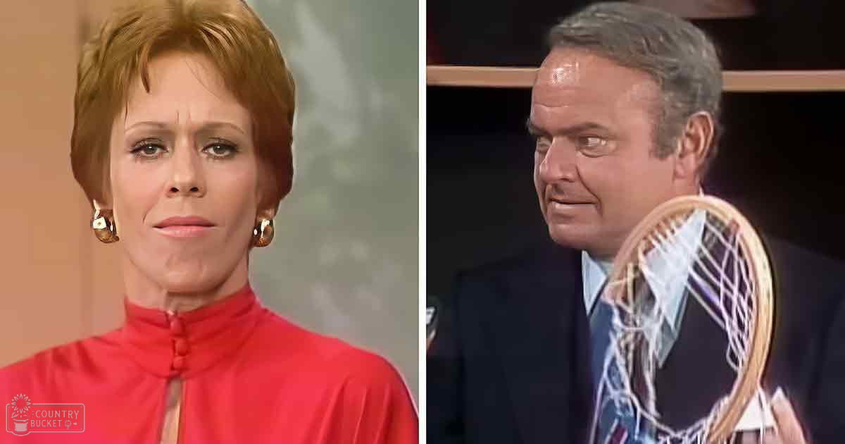 Adult female wearing a red high-necked top with buttons, gold hoop earrings, and an adult male in a dark suit jacket with a white shirt and patterned tie, in a professional indoor studio setting.