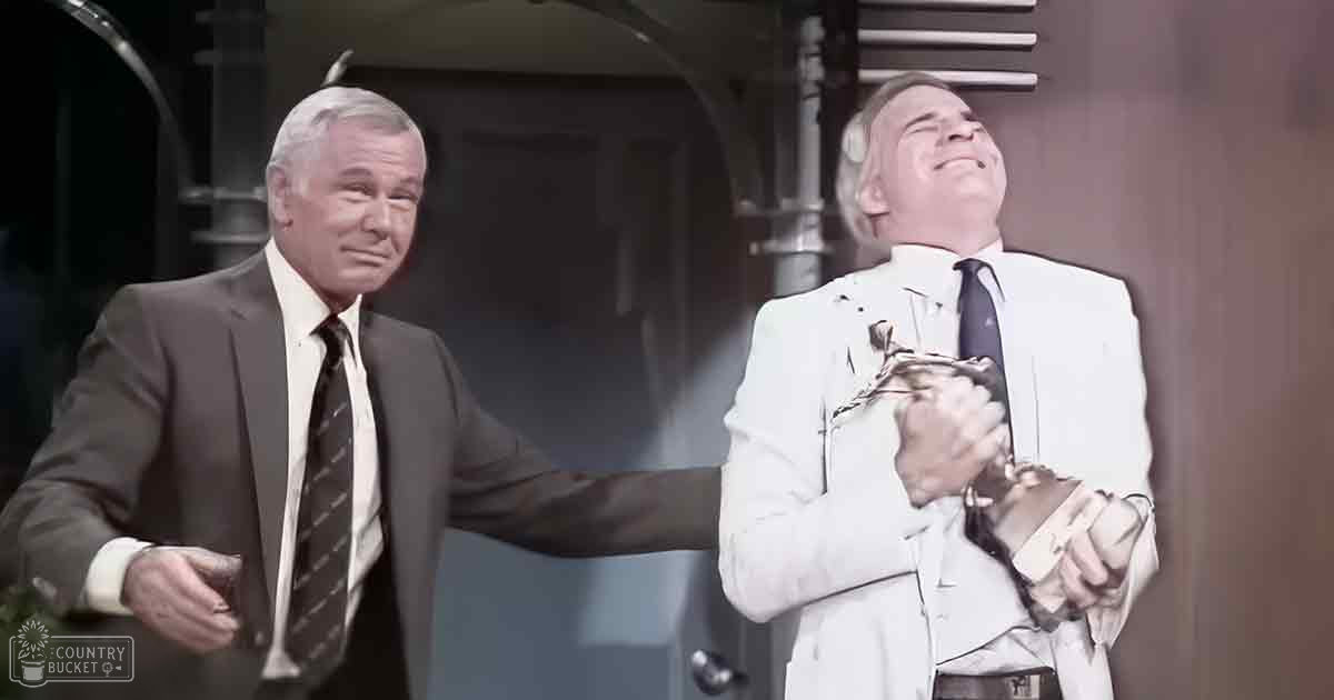 Two older adult men wearing formal suits indoors with natural light, possibly a hallway or office building.