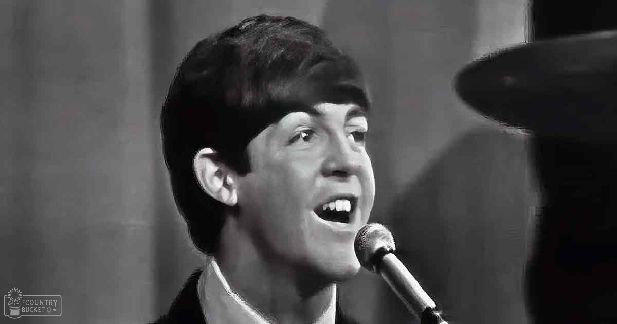 A young adult male singing into a microphone in what appears to be a music studio setting.