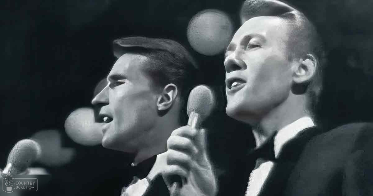 A musical performance scene from the mid-20th century with two young adult male performers in formal dark-colored suits against a stage-like background with blurred stage lighting.
