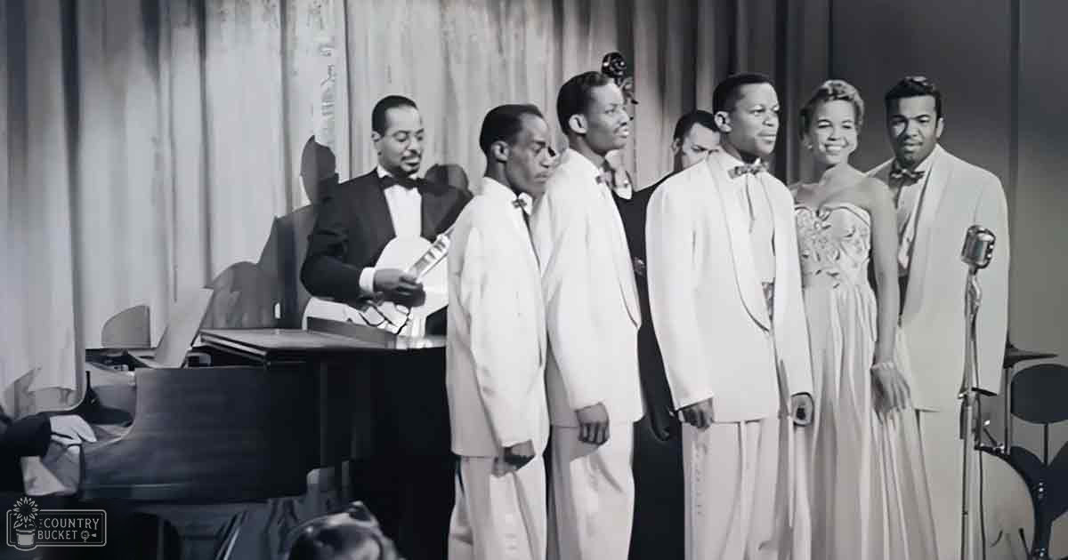 A mid-20th century musical performance with performers in suits, a grand piano, microphones, and sheet music stands under heavy curtains indoors.