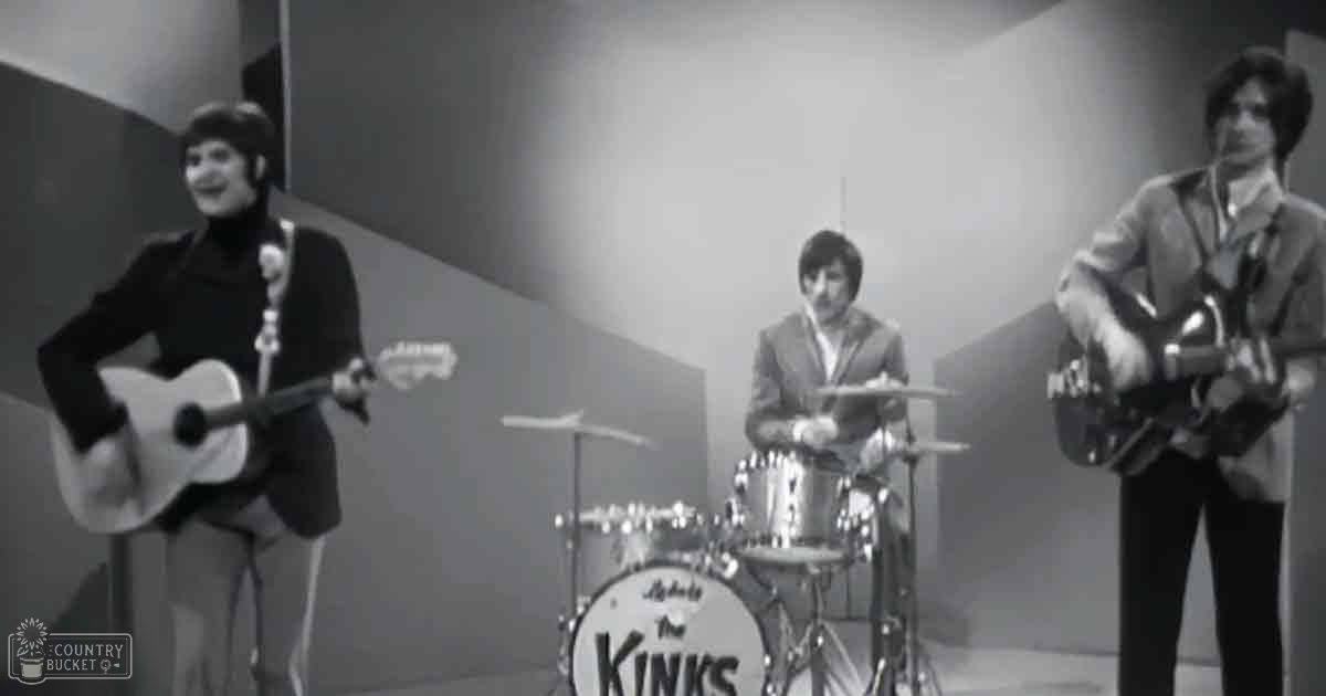 A musical performance scene in an indoor studio with performers wearing mid-20th century attire, including a black turtleneck sweater and dark pants for the female singer, and formal suits for the male musicians.