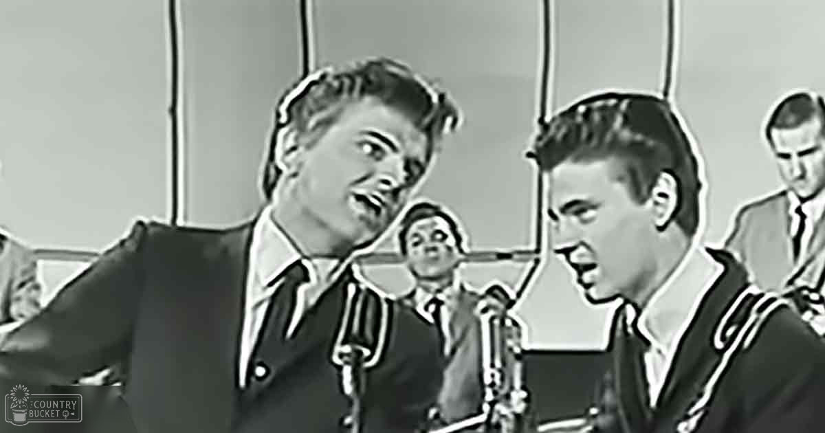 A mid-20th-century musical performance scene indoors, with well-dressed male performers in formal attire under artificial lighting.