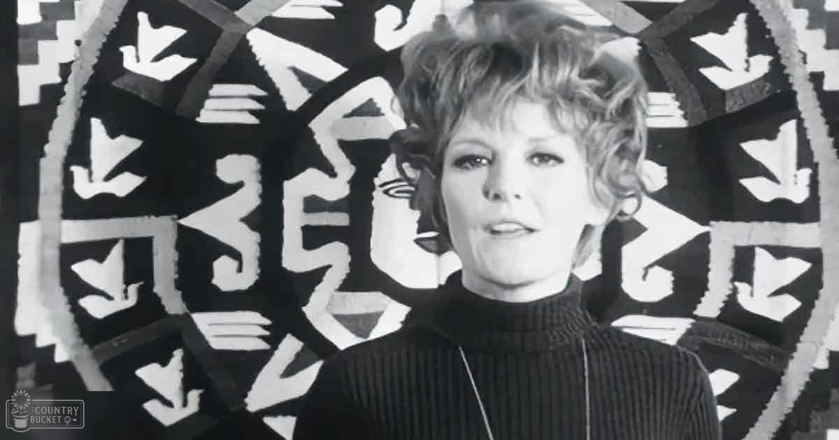 Middle-aged adult female in an indoor setting with abstract black-and-white geometric wall art, even diffused lighting, 1970s or early 1980s ribbed turtleneck sweater, solid color, knit fabric, artistic urban environment