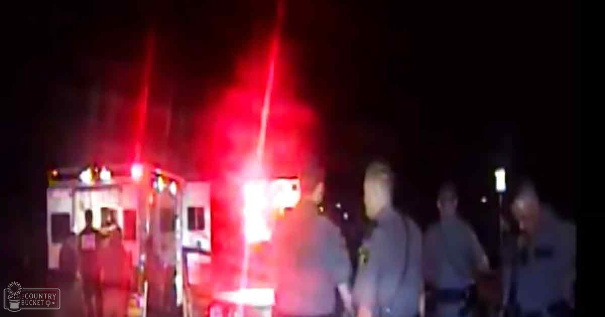 Emergency responders at a nighttime fire scene with an ambulance, dark background, red lights.