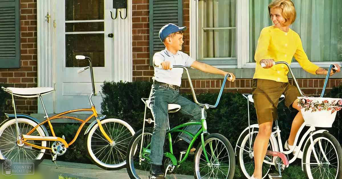 A family scene in front of a brick house with three bicycles and soft evening light, suggesting late afternoon or early evening.
