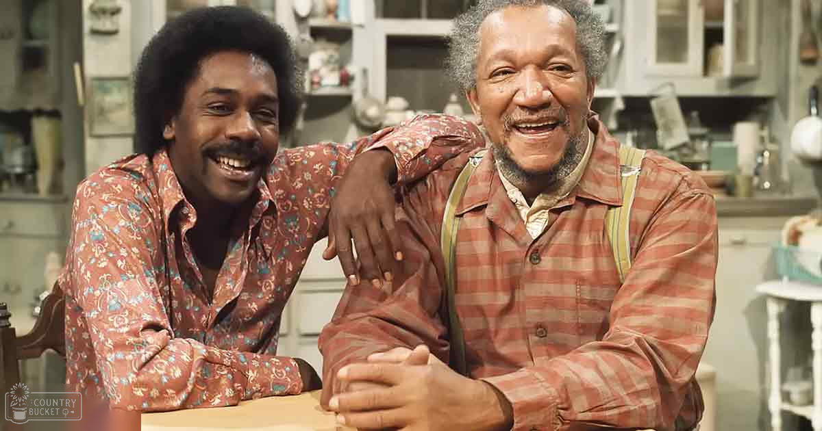 Two young adult males wearing patterned shirts in a well-used kitchen setting with shelves of kitchenware.