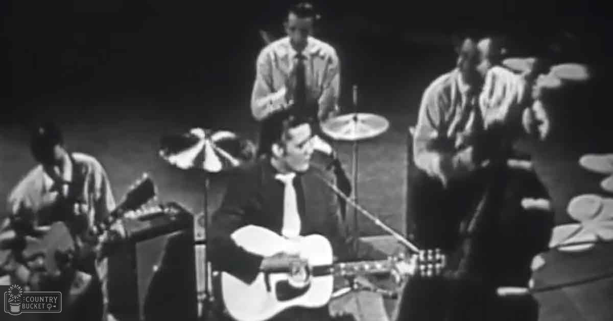 A mid-20th century musical performance with four adult male musicians playing various instruments on a stage in an indoor venue.