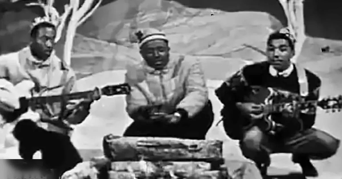 Musicians performing outdoors on a rocky landscape with muted tones and clear daytime lighting.