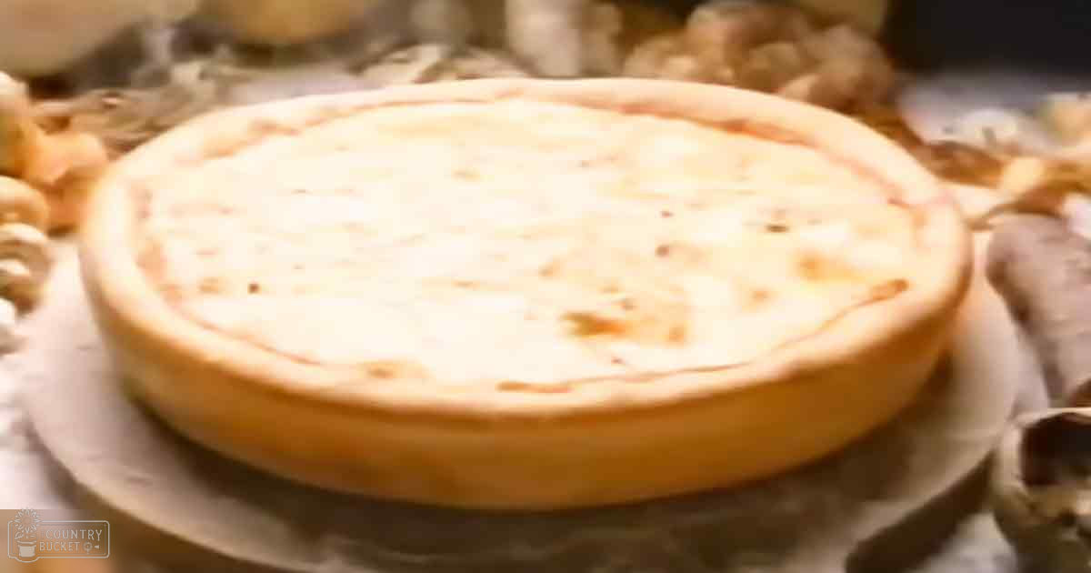 A baked dish with golden-brown crust on parchment paper in an indoor setting with warm, soft lighting.