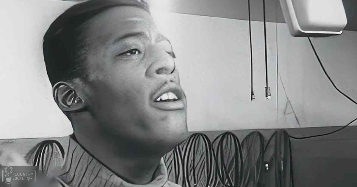 A young adult male in a casual indoor setting wearing a striped V-neck shirt.