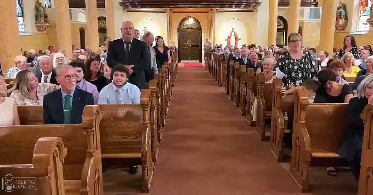 A church service with wooden pews, stained glass windows, ornate architecture, and a mix of dressed-up adults in formal attire suggesting spring or summer.
