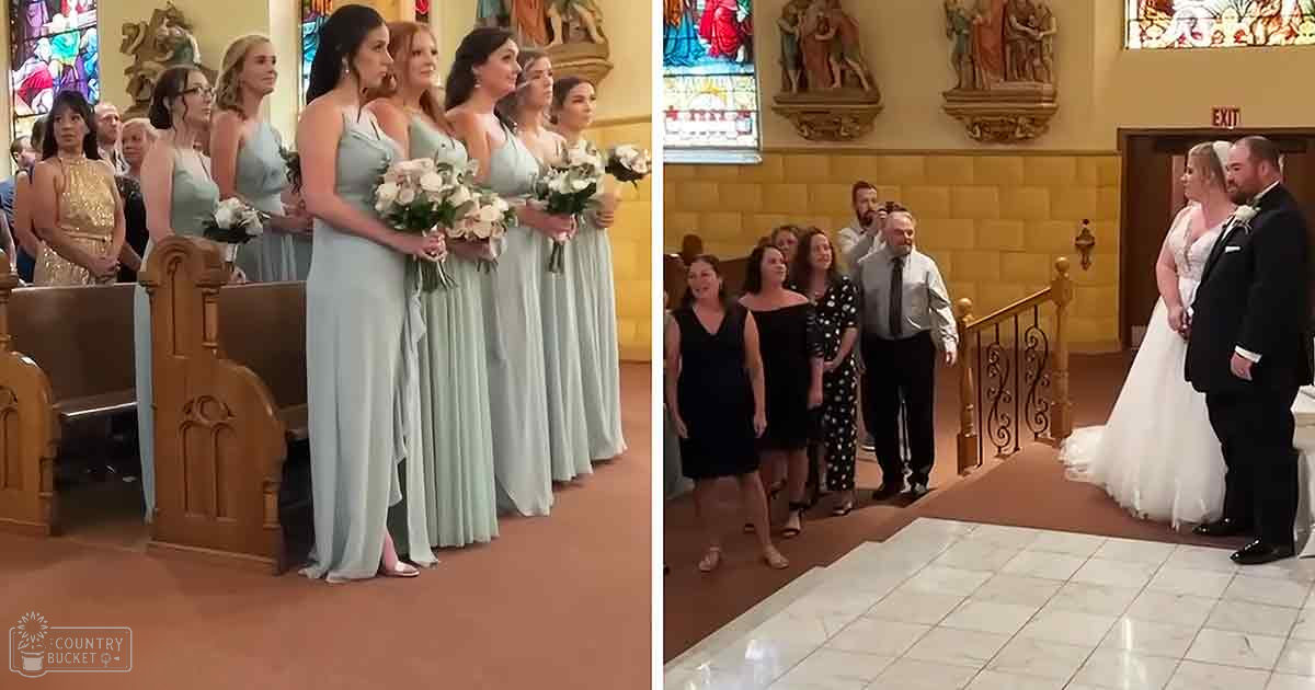 A wedding ceremony taking place in a church with bridesmaids wearing light blue dresses holding white bouquets, family members in formal attire standing on the right side, and stained glass windows illuminating the interior.