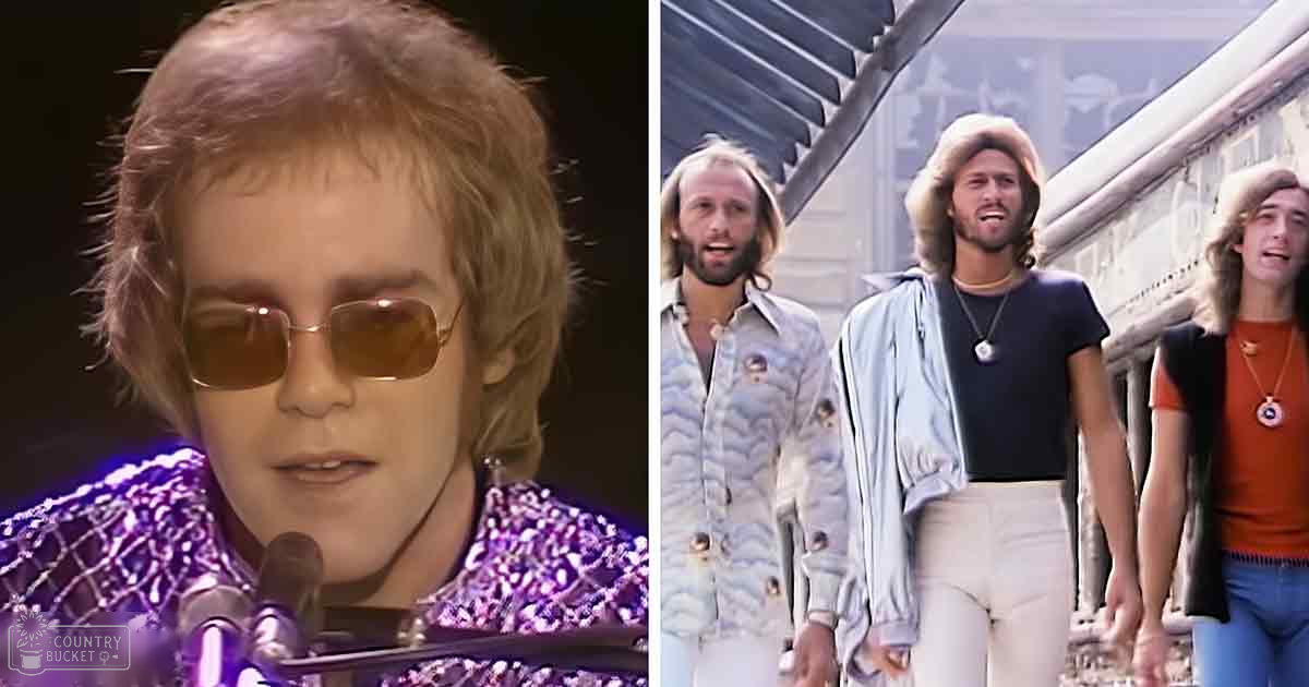 Three adult males standing outdoors near an industrial structure under natural daylight; one wearing a patterned purple shirt with sequins, another in a white pantsuit, and the third in an orange t-shirt with a black vest. Microphone stand visible.