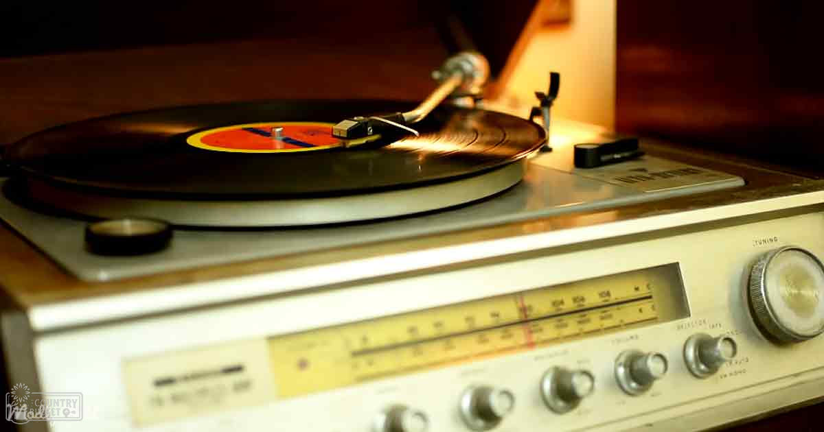 A vintage record player with a vinyl record on it, set in an indoor environment with wooden elements and warm ambient lighting.