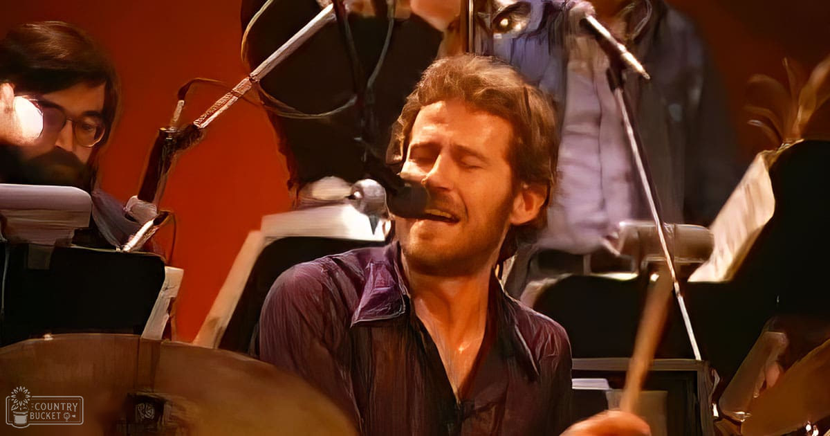An adult male drummer performing indoors at a music venue or studio.